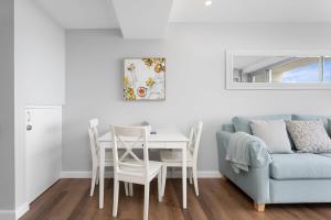 - un salon avec une table et un canapé bleu dans l'établissement Modern Manly Apartment with Stunning Views, Pool, à Sydney