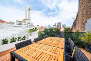 a wooden table and chairs on a rooftop patio at Sublime Locale with Skyline Views from Courtyard in Sydney