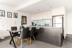 a kitchen with a table and chairs and a refrigerator at Spacious 2-Bed with Two Balconies with City Views in Sydney