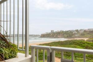 a balcony with a view of a beach at Chic Beachside Apartment Freshwater in Freshwater