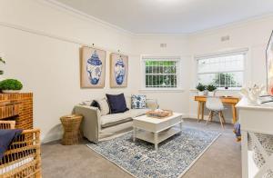 ein Wohnzimmer mit einem Sofa und einem Tisch in der Unterkunft Art Deco Apartment Meters Away From The Beach in Sydney
