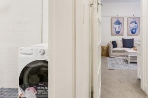 uma sala de estar com uma máquina de lavar roupa e um sofá em Art Deco Apartment Meters Away From The Beach em Sydney