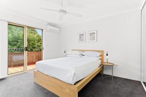 um quarto com uma cama e uma grande janela em Pristine 2-Bed Near Marrickville Village em Sydney