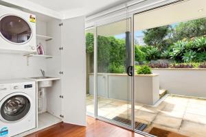 a laundry room with a washer and dryer at Clovelly Beach House - Sea, Sand and Exclusivity in Sydney