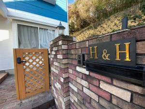 H&H - Vacation STAY 14242 في كيتاكيوشو: جدار من الطوب مع علامة وباب