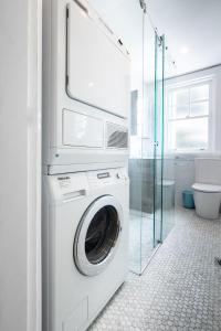 a laundry room with a washer and dryer in a bathroom at Snug 1-Bed Unit Across from Bondi Beach in Sydney