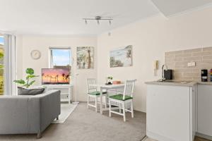 uma cozinha e sala de estar com um sofá e uma mesa em Charming 1-Bed Apartment Close to Shops and Parks em Sydney