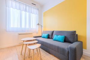 a living room with a couch and a table at Marcq-en-Baroeul - App art deco equipped for 2! in Marcq-en-Baroeul