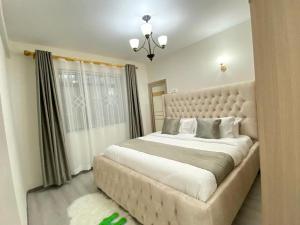 a bedroom with a large bed with a large headboard at Cozy Haven in Nairobi