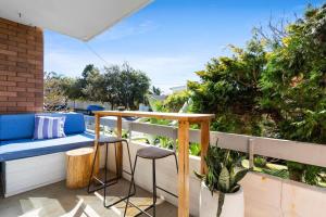 een patio met een bank en krukken op een balkon bij Beautiful Boho 3-Bed by the Beach & the Bush in Sydney