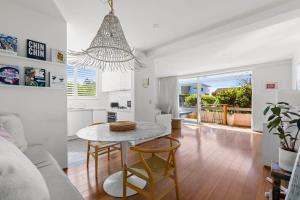 een keuken en een woonkamer met een tafel en stoelen bij Beautiful Boho 3-Bed by the Beach & the Bush in Sydney