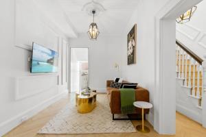 een woonkamer met een bank en een tafel bij Superb 3-Bed Victorian Terrace by Darling Harbour in Sydney