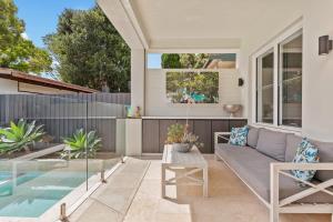 a patio with a couch and a table at Impeccably Chic 4-Bed Home with Spa & Pool in Sydney