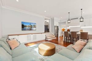 a living room with a couch and a table at Impeccably Chic 4-Bed Home with Spa & Pool in Sydney