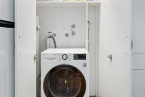 Una lavadora y secadora en una habitación blanca en Stunning double-story waterfront retreat, en Sídney