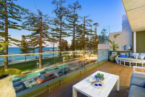 a living room with a balcony with a view of the ocean at Glorious Beachfront 3-Bed with Breathtaking Views in Deewhy