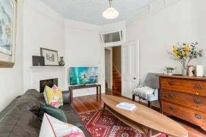 a living room with a couch and a coffee table at Quaint 3-Bed Heritage Home in the Heart of Sydney in Sydney