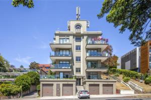 a tall white building with a cross on top at Superb 2-Bed Apartment Facing Rose Bay Marina in Sydney