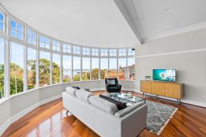 uma sala de estar vazia com um sofá e uma televisão em Huge Harbour View Apartment In Historic Home em Sydney