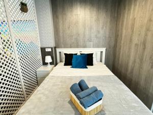 a bedroom with a bed with blue pillows on it at Grandera Apart`s - Lliri 32 in Valencia