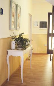une table blanche avec une plante dans une pièce dans l'établissement B&B Santa Sofia, à Gravina di Catania