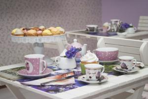 a table topped with cups and a plate of desserts at B&B Santa Sofia in Gravina di Catania