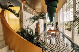 eine Lobby mit Pflanzen und einer Couch in einem Gebäude in der Unterkunft Hotel Estefania Boutique Suites in Los Cristianos