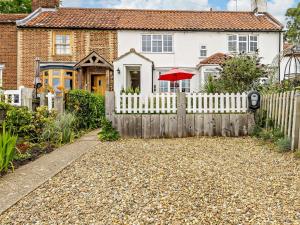a white fence in front of a house at 3 Bed in Reedham 47835 in Haddiscoe
