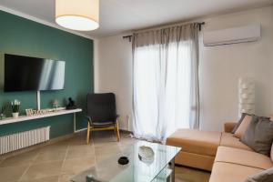 a living room with a couch and a tv at medusa apartment in glyfada in Athens