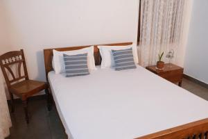 1 dormitorio con 1 cama grande con almohadas azules y blancas en My Gramam Homestay, en Vāzhākulam