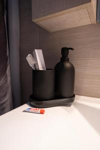 a black soap dispenser sitting on top of a counter at medusa apartment in glyfada in Athens