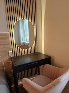 a mirror and a chair in a room with a table at Premium Avkoppling Tre Rum av Perfektion in Gothenburg