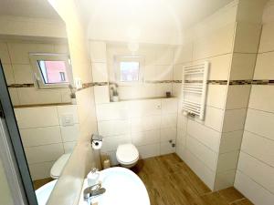 a small bathroom with a sink and a toilet at Hotel Kolossos Düsseldorf - Neuss in Neuss