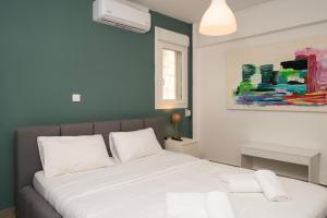 a bedroom with a bed and a painting on the wall at medusa apartment in glyfada in Athens