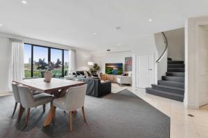 - un salon avec une table, des chaises et un canapé dans l'établissement Spacious 3-Bed Apartment by the MCG, à Melbourne