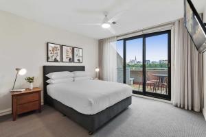 a bedroom with a large bed and a large window at Spacious 3-Bed Apartment by the MCG in Melbourne