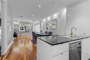 a kitchen and living room with a table and chairs at Stylish and Spacious 2-Bed Apartment Melbourne in Melbourne