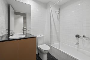 a bathroom with a toilet and a sink and a shower at Stylish and Spacious 2-Bed Apartment Melbourne in Melbourne