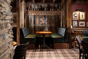 a bar with green seats and a table and chairs at The Ambleside Inn - The Inn Collection Group in Ambleside