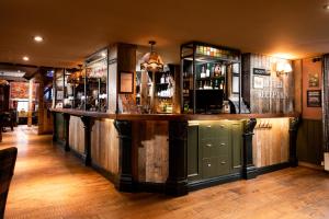 a bar in a pub with wooden walls at The Ambleside Inn - The Inn Collection Group in Ambleside