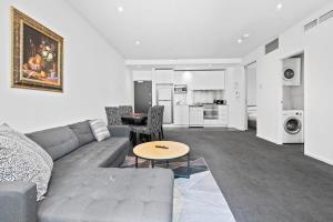 sala de estar con sofá y mesa en Sleek 2-Bed Apartment with Beautiful City Views, en Melbourne