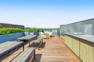 a balcony with benches and a sink and a kitchen at Beautiful 1-Bed Unit in The Heart of Melbourne in Melbourne