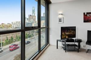 a living room with a view of a city at Beautiful 1-Bed Unit in The Heart of Melbourne in Melbourne