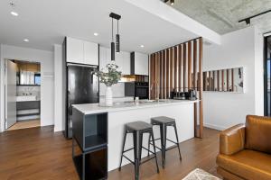 a kitchen with a counter and stools in a room at Executive 2-Bed Apartment with Views, Gym and Pool in Melbourne