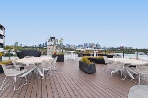 a patio with tables and chairs on a deck at Executive 2-Bed Apartment with Views, Gym and Pool in Melbourne