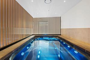 a swimming pool with blue water in a room at Executive 2-Bed Apartment with Views, Gym and Pool in Melbourne
