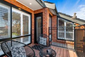 a balcony with two chairs and a bird on it at Delightful 2-Bed Townhouse Close to the Beach in Frankston