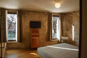 a bedroom with a bed and a tv and windows at Locanda Ponte Dante in Treviso