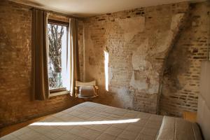 a bedroom with a bed and a window at Locanda Ponte Dante in Treviso