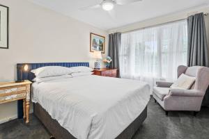 sypialnia z dużym łóżkiem i krzesłem w obiekcie Snug 1-Bed Unit near Essendon Football Grounds w Melbourne